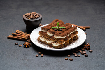 Classic tiramisu dessert on ceramic plate on concrete background
