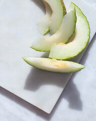 Slice of melon on white marble background