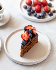 tasty chocolate cake and berries on marble background with copy space