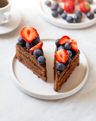 tasty chocolate cake and berries on marble background with copy space