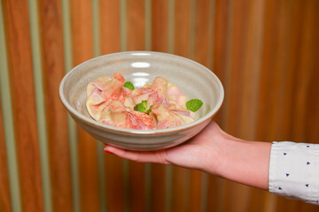 Waiter serves georgian meat dumplings called khinkali. Delicious dinner, Georgian cuisine.