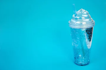 Foto op Aluminium Take away cold drinks. Travel gliter plastic cup wilh straw for ice coffee or coctails. Blue background, copyspace. © OneWellStudio