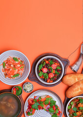 A lot of food over bright orange background. Georgian cuisine. Top view. Flat lay. Lenten menu, vegetarian dishes.