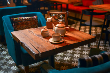 White tea set served on a rustic wooden table in a restaurant. Tea time. Ceramic tea set. Eating out concept.
