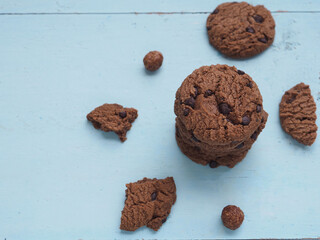 Stack homemade double chocolate chip cookies on blue wooden background. View from above, copy space...
