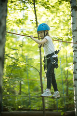 A little girl standing on the rope with full insurance and having an entertainment