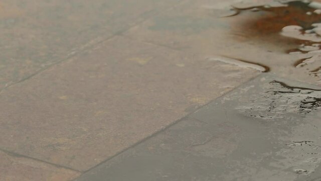 Rain falling on stone table close up in Oregon June on a deck along the river