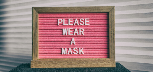 Please wear a mask pink sign at business store entrance message. Obligatory wearing of COVID-19...