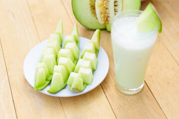 Fresh green melon on wood plate