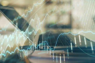 Forex graph hologram on table with computer background. Double exposure. Concept of financial markets.