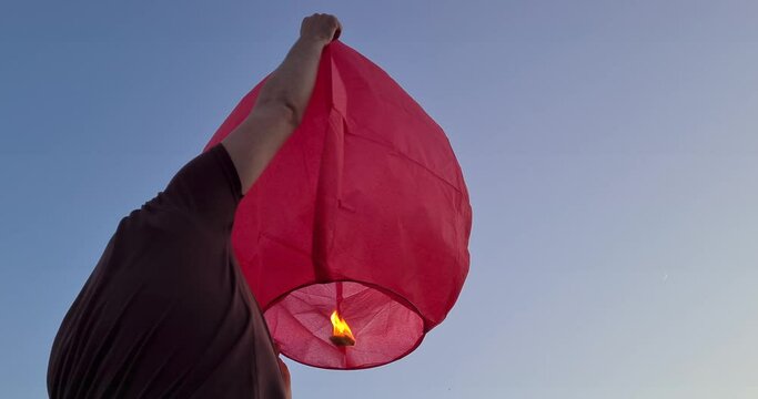 Happy father with his son and daugter flying fire lantern together