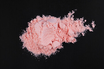 Pink protein powder with strawberry flavor on a black background. Sports supplements and nutrition...