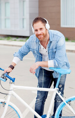 Fototapeta na wymiar Casual guy next to a vintage bicycle listening music