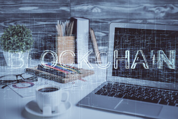 Double exposure of blockchain and crypto economy theme hologram and table with computer background....