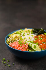 Hawaiian salmon poke bowl with seaweed, avocado, sesame seeds.