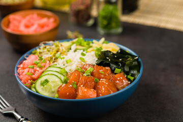 Hawaiian salmon poke bowl with seaweed, avocado, sesame seeds.