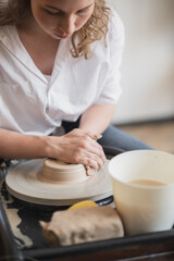Hands of a potter, creating an earthen jar on the circle