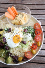 combinate dish with olives tomatoes broccoli and fried egg