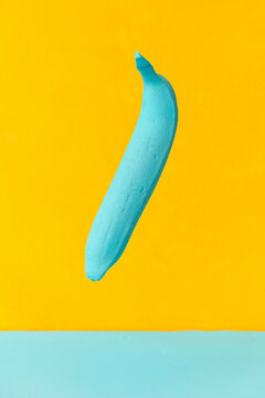painted blue banana on a yellow background. creativity design concept