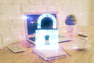 Double exposure of desktop with computer and lock icon hologram. Concept of data safety.