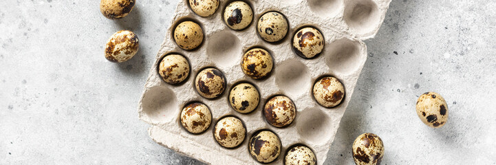 Eggs on a tray on the kitchen table. Quail eggs on a culinary background. Concept of preparation for baking. Top view with space for text. Banner