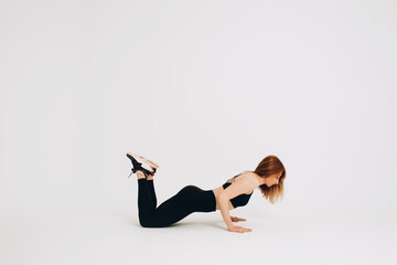 Fit woman stretching her leg to warm up - isolated over white background