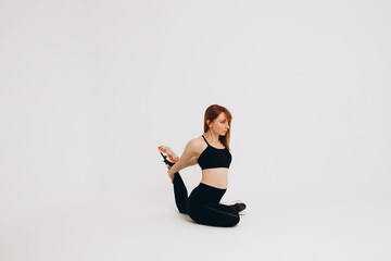 Obraz premium Fit girl warming up. Full length of young african girl in sportswear stretching her arms on white background. Stretching and motivation