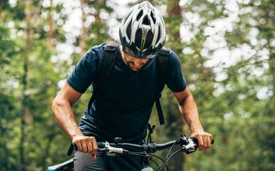 Horizontal outdoor image of cyclist man riding bike in the mountain. Male athlete in cycling gear...