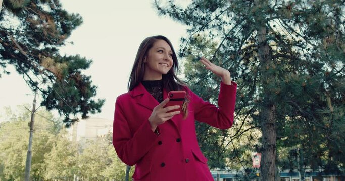 Close up of Beautiful Woman waks using her Modern Smartphone.