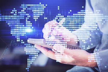 Double exposure of hands and notepad with business icons.