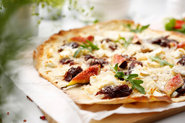 A flatbread with goat cheese, figs and red onion jam. Tasty pizza on crunchy dough.