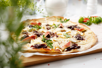 A flatbread with goat cheese, figs and red onion jam. Tasty pizza on crunchy dough.