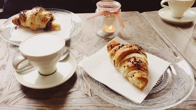 Cappuccino and chocolate croissant in cafe, cup of coffee and pastry dessert for breakfast, food and baked goods close-up