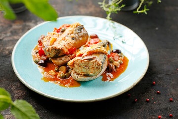 Mackerel baked in tomato sauce with capers. Suggestion of serving a dish on a plate. food background