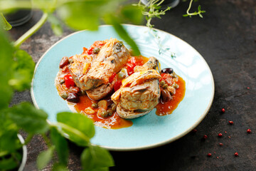 Stewed mackerel in tomato sauce with capers served on toast. Suggestion of serving a dish on a plate. food background