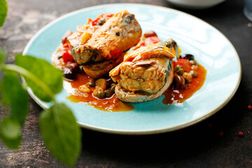 Mackerel baked in tomato sauce with capers. Suggestion of serving a dish on a plate. food background