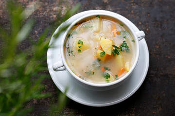 Vegetable soup, healthy soup made of fresh vegetables. Home cooking. vegetarian. Dish in a plate on a dark background.
