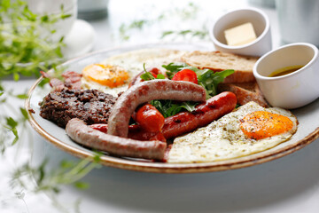 
Breakfast. Fried eggs, fried sausages, black pudding, salad.