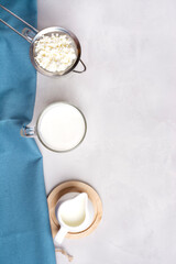 Fermented kefir drink with kefir grains. Homemade kefir, next to kefir grains, milk and a blue towel on a gray background. Vertical orientation. Bulgarian drink. Top view, there is a space mine.