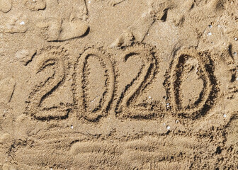 Summer, year and vacation 2020. The inscription, the words written in the sea sand. Photograph, copy space.