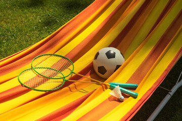 badminton rackets and a soccer ball in a hammock