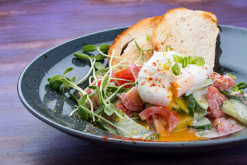 Homemade salad with vegetables and poached egg. Breakfast.