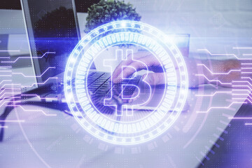 Obraz premium Crypto currency theme hologram with businessman working on computer on background. Concept of blockchain. Multi exposure.