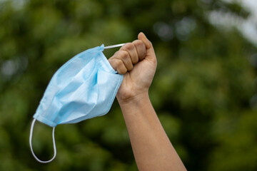 hand holding a a surgical nose mask