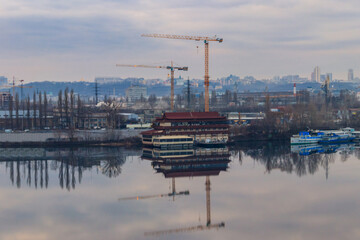 View of the Dnieper river and construction cranes on right bank in Kiev, Ukraine