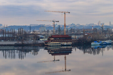 View of the Dnieper river and construction cranes on right bank in Kiev, Ukraine