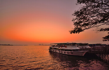 Fototapeta na wymiar A ferry parked on the banks of Vembanad lake during sunset in Kochi