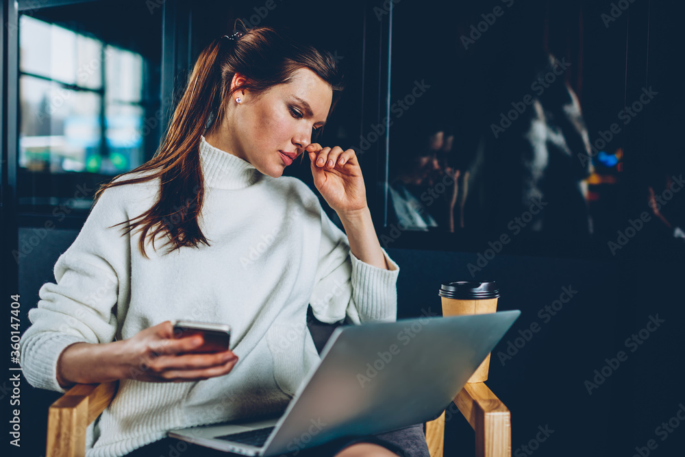 Poster caucasian charming woman watching webinar on laptop computer while browsing wireless internet on sma