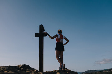 A happy hiker woman standing on the summit