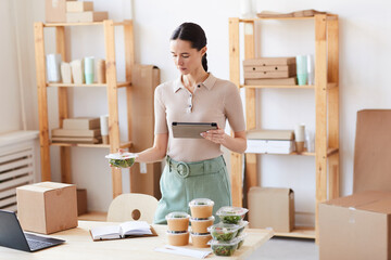 Young woman using digital tablet she working at office and organizing the food delivery